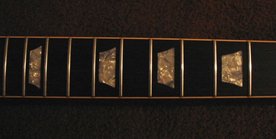 Guitar fretboard with mother-of-pearl inlays and metal frets