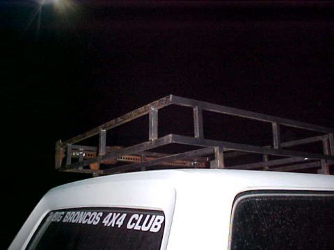 1987 Ford Bronco - A custom metal roof rack is mounted on the roof of a white vehicle with a "BIG BRONCOS 4X4 CLUB" sticker.