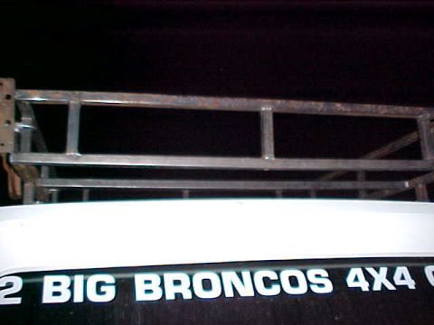 1987 Ford Bronco - A custom roof rack is mounted above the rear of a vehicle that has "2 BIG BRONCOS 4X4" text on its tailgate.