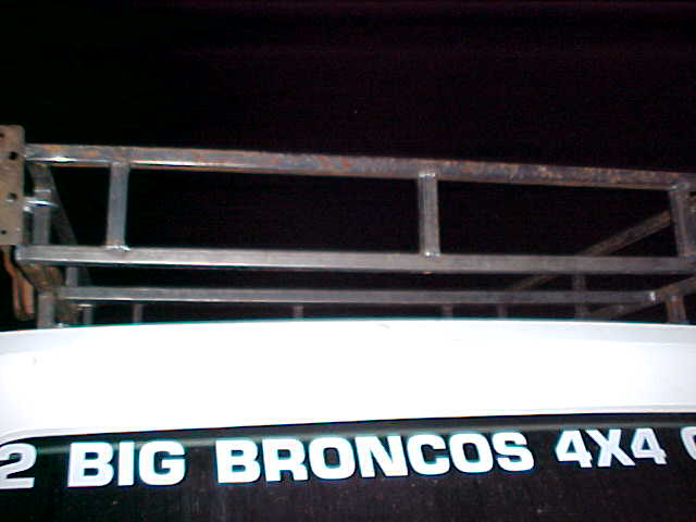 Roof rack over white vehicle with text "2 BIG BRONCOS 4X4"