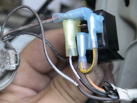 1993 Ford C-350 (Centurion Conversions) - A hand is shown holding a vehicle's wiring harness with multiple connectors and a relay attached.