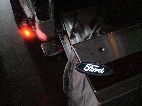 1993 Ford C-350 (Centurion Conversions) - Close-up of a Ford emblem and wiring on a vehicle's tailgate, with an illuminated tail light visible.