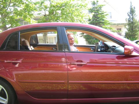 2004 Acura TL - Side view of a red 2004 Acura TL sedan with a driver visible through the window.