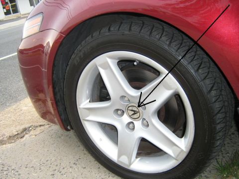 2004 Acura TL - Acura wheel with center cap and tire.