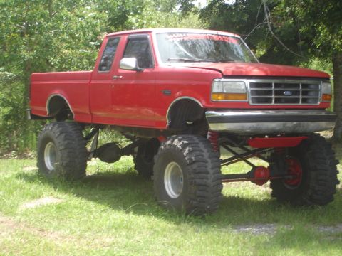 1989 Ford Bronco - This lifted pickup truck features oversized tires and a modified suspension system, viewed from the front quarter angle.