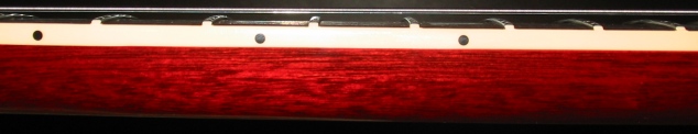 Red wood guitar neck with frets and fret markers