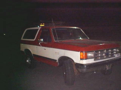1987 Ford Bronco - This 1987 Ford Bronco features a two-tone red and white paint scheme and a prominent grille.