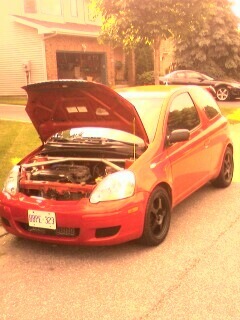 2002 Nissan SE-R - A red hatchback is parked in a driveway with its hood open, revealing the engine bay.