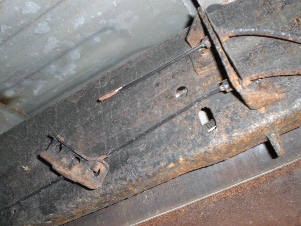 E-brake cables attached to rusty frame