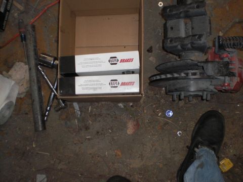 1995 Ford F-150 - Parts laid out on the floor, including a brake assembly and NAPA brake pads.