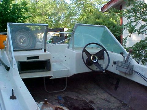 1987 Ford Bronco - Interior view of a boat, showing the helm and controls, with a spare tire mounted.