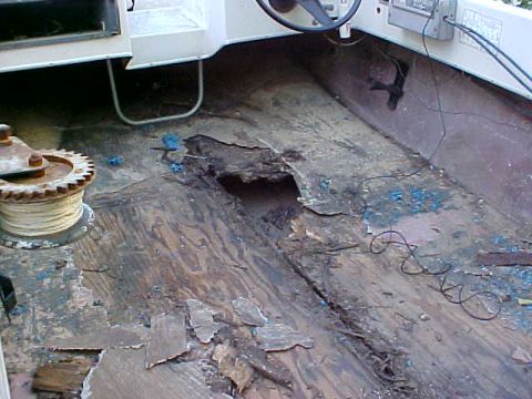 1987 Ford Bronco - The interior of a boat shows significant damage to the wooden floor, revealing the underlying structure.