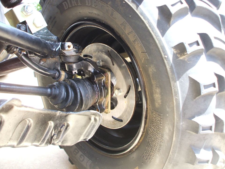 Close-up of an ATV rear wheel hub, brake disc, CV axle boot and Dirt Devil tire