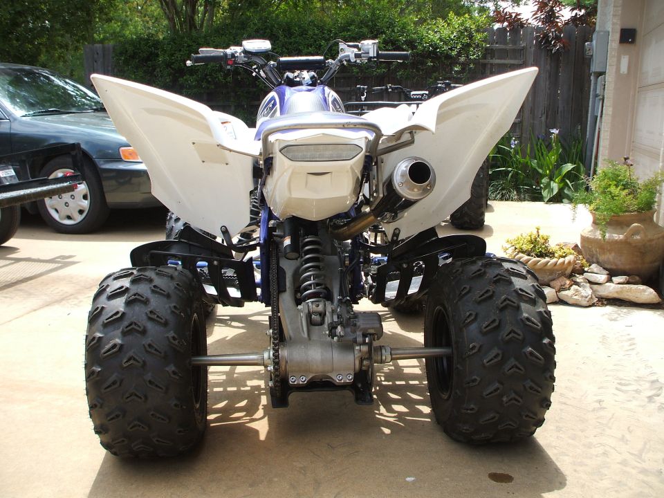Rear view of white and blue Yamaha Raptor sport ATV on a driveway