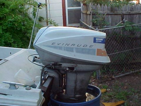 1987 Ford Bronco - Evinrude outboard motor on a boat, with a blue barrel catching drips.