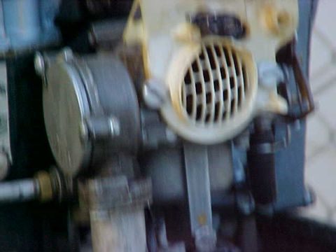 1987 Ford Bronco - Close-up view of engine parts, including a carburetor with a distinctive grille.