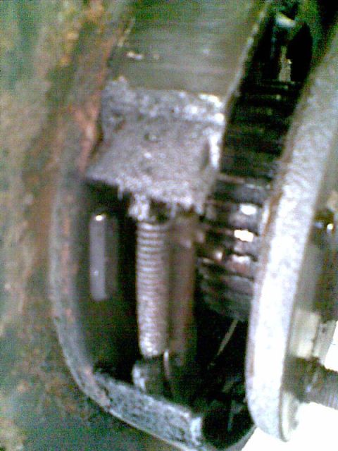 2003 Ford Crown Victoria - A close-up view shows a rusty spring and metal components, possibly part of a brake system or suspension, within a vehicle.