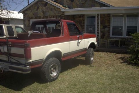 1987 Ford Bronco - This 1987 Ford Bronco features a two-tone red and white paint scheme and is equipped with a lifted suspension and 31-inch tires.