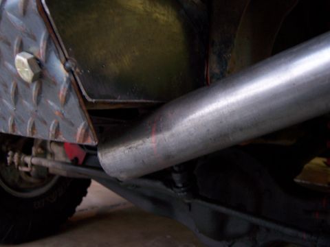 1991 Ford Bronco - Detail shot of a vehicle's undercarriage, focusing on the exhaust system and a custom bumper modification.