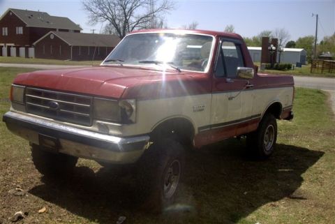 1987 Ford Bronco - This two-tone pickup truck appears to be a 1987 Ford Bronco, modified with a lift kit and 31-inch tires.