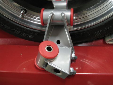 1994 Ford Probe - Close-up of an aftermarket suspension part with red bushings, next to a tire.