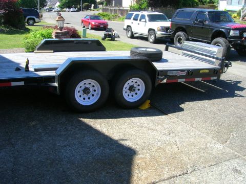 1996 Ford Bronco - A black 1996 Ford Bronco is parked on a trailer, with a white SUV and a red car visible in the background.
