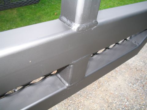 1989 Ford Bronco - Custom steel bumper with diamond plate inserts and visible welds.