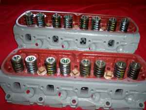 1989 Ford Bronco - Two cylinder heads, likely for a V8 engine, are shown with their valve springs and retainers installed. The SuperMotors.net logo is visible…
