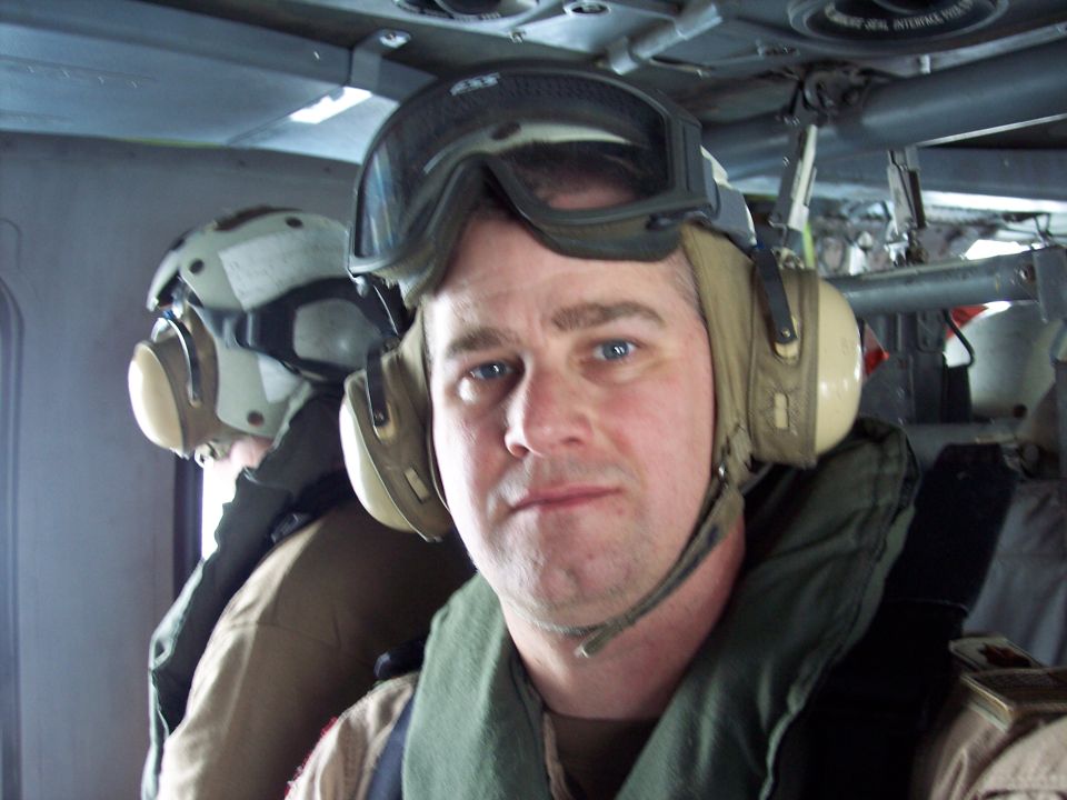 Interior of a helicopter with two people wearing helmets and headsets