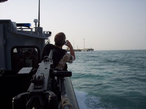 1981 Kenworth W900A - A man on a boat takes a photo of an oil rig while a machine gun is mounted nearby.