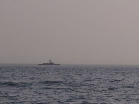 1981 Kenworth W900A - A solitary boat navigates the choppy waters under an overcast sky.