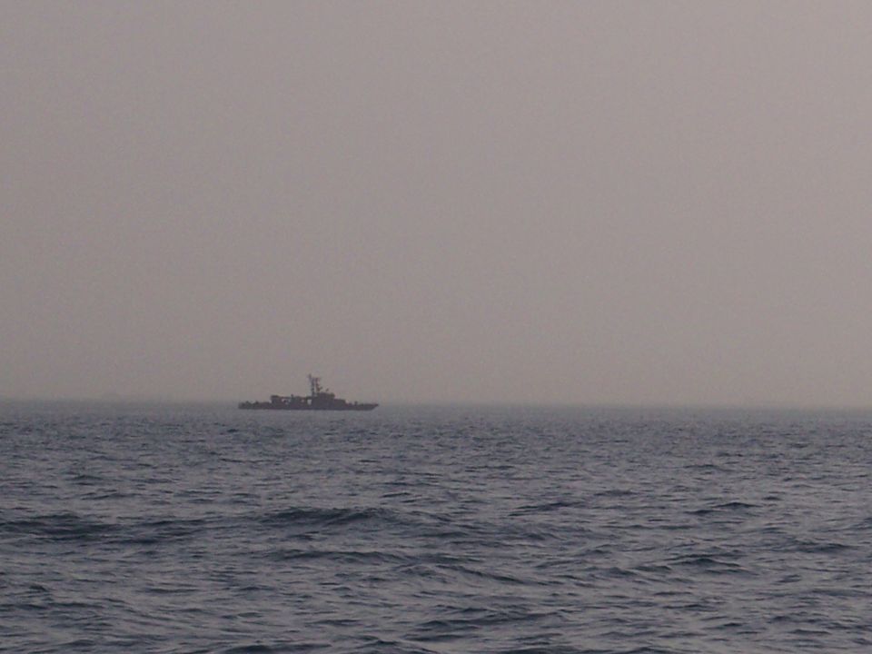 Boat on the water under a hazy sky