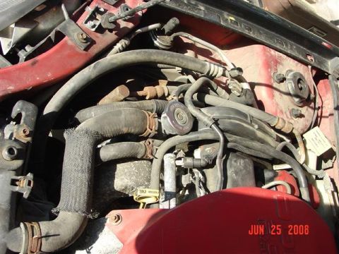 1997 Dodge Neon - A close-up view of a vehicle's engine bay, showing various hoses and mechanical parts.