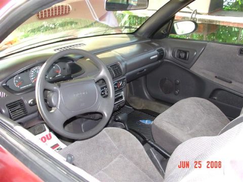 1997 Dodge Neon - The interior of a car is shown, the dashboard, steering wheel, and passenger seats. A date watermark is visible.