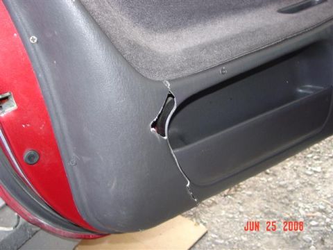 1997 Dodge Neon - The interior door panel shows damage and a storage pocket.