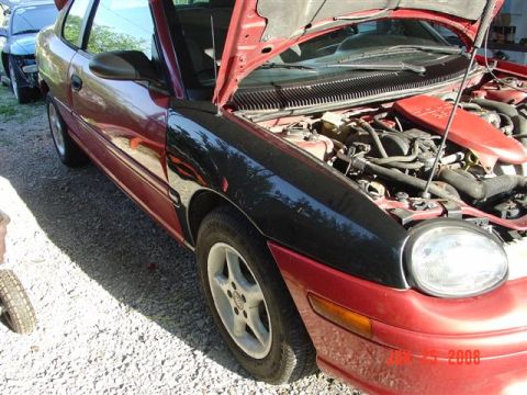 1997 Dodge Neon - This 1997 Dodge Neon has a mismatched black fender and its hood is open, revealing the engine bay.