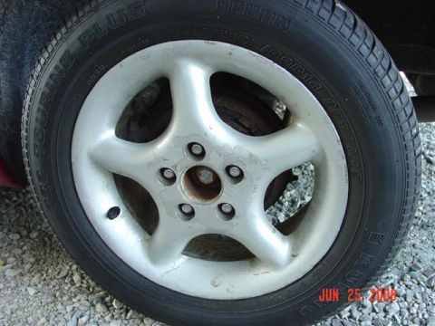 1997 Dodge Neon - A close-up view of a silver five-spoke wheel and tire, with visible tire size information.