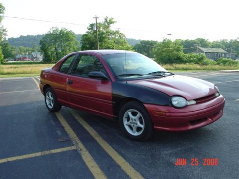 1997 Dodge Neon - A two-tone coupe, red with a black hood, sits in a parking lot on a sunny day.