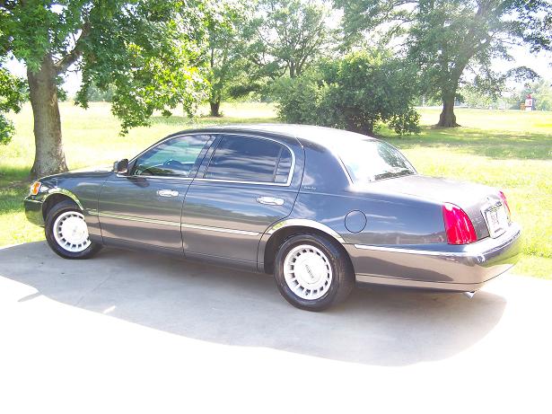1998 Lincoln Town Car, dark gray, parked on concrete driveway with trees and grass in background