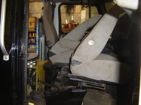 1992 Ford Bronco - The interior of a vehicle shows two tan fabric seats with visible metal seat rails and black trim.
