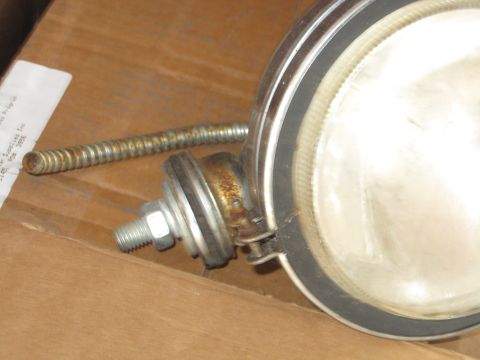 1990 Ford Bronco - A headlight assembly is shown with its mounting hardware and a flexible conduit.