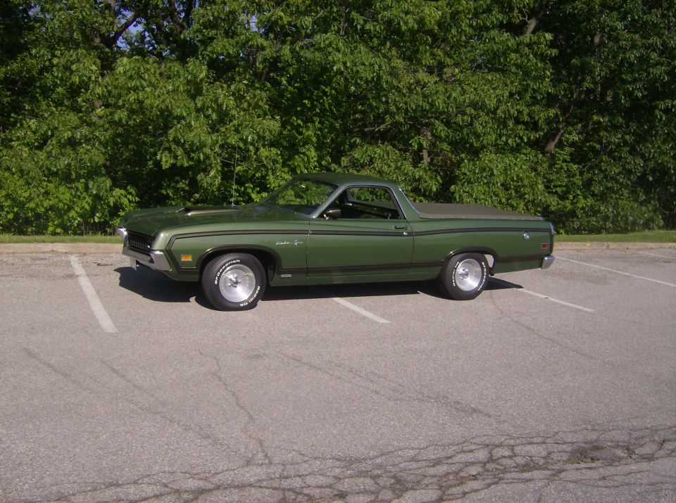 Dark green Ford Ranchero side profile with black tonneau and chrome wheels