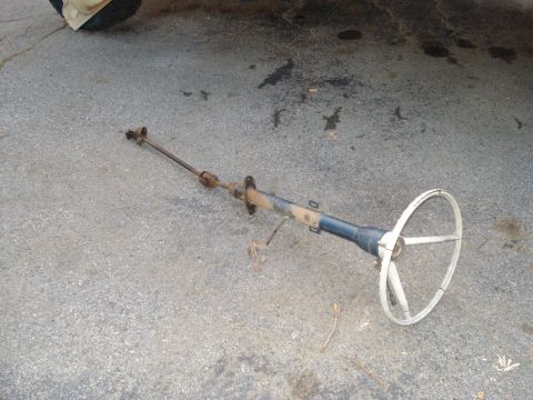 1967 Ford F-250 - A disassembled steering column and wheel are shown on a paved surface.