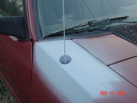 1984 Ford Mustang - Detail of a car's hood and fender, showing a primer patch and an antenna mount. Date stamp is visible.