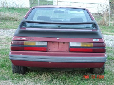 1984 Ford Mustang - Rear view of a red 1984 Ford Mustang hatchback with a black spoiler and 5.0 badging.