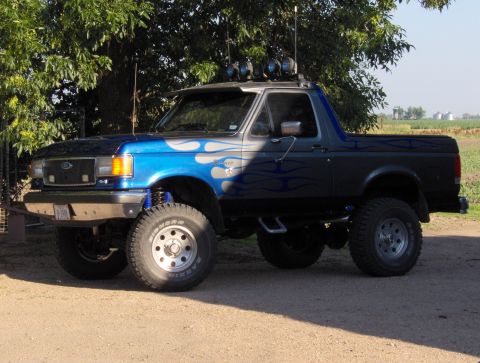 1987 Ford Bronco - This lifted Ford Bronco features custom flame paint and off-road modifications.