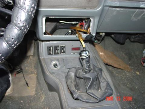 1984 Ford Mustang - The interior of a 1984 Ford Mustang shows a manual transmission shifter and a damaged dashboard area.