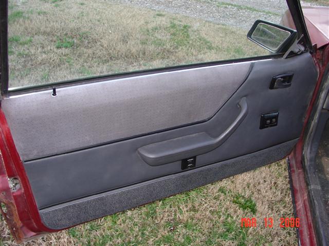1984 Ford Mustang interior door panel with gray fabric and dark gray plastic trim