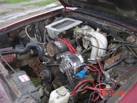 1984 Ford Mustang - Engine bay of a 1984 Ford Mustang, showing the V8 engine components and wiring.