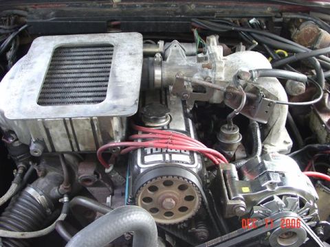 1984 Ford Mustang - Close-up of an engine bay an intercooler and turbocharger, with visible text indicating 'TURBO' and a date stamp.
